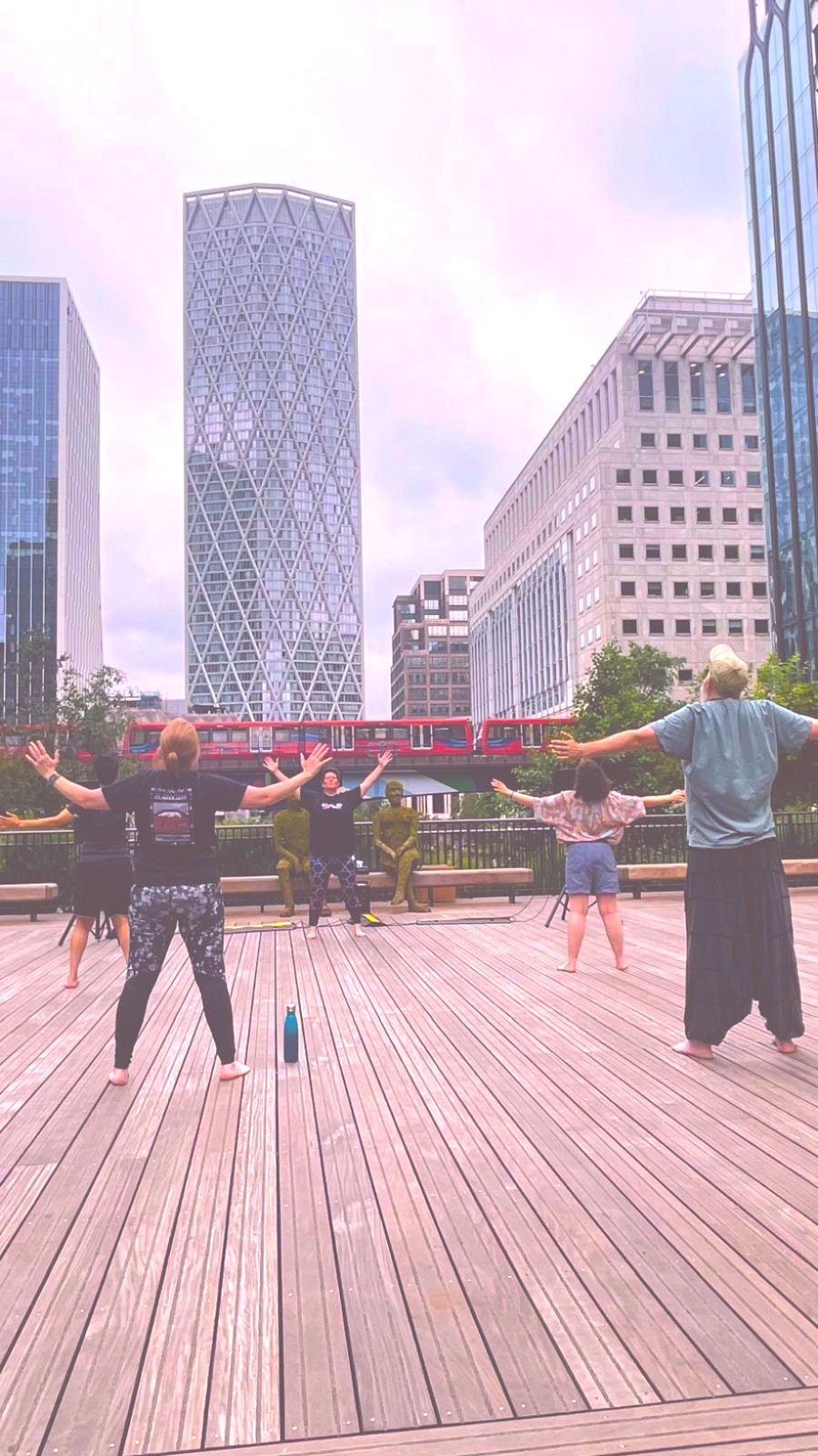 A group of people practising tai chi qigong together at the Canary Wharf Pride in Wellness Festival
