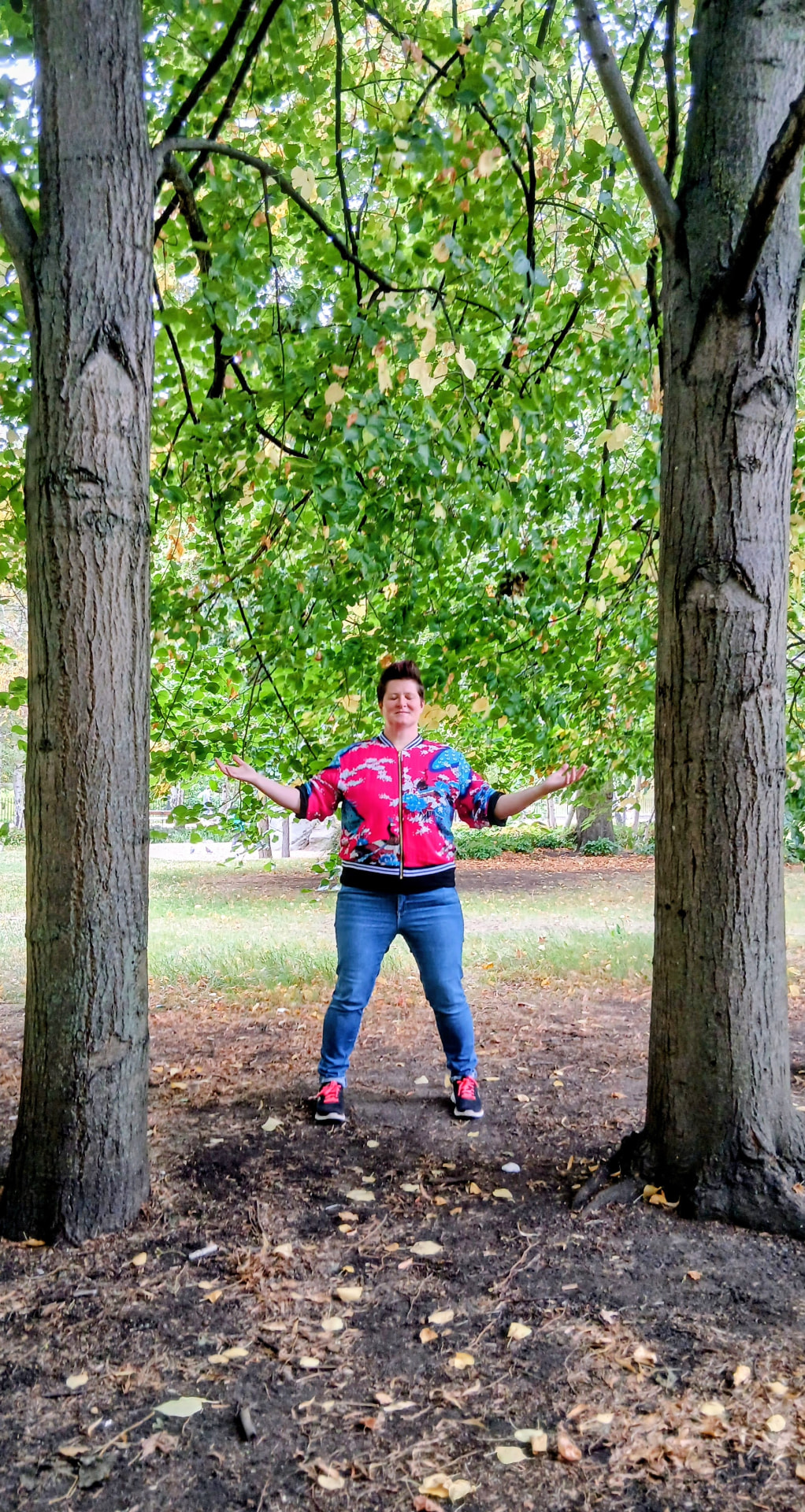 A one-to-one qigong session, with the teacher adjusting a student's arm position and stance