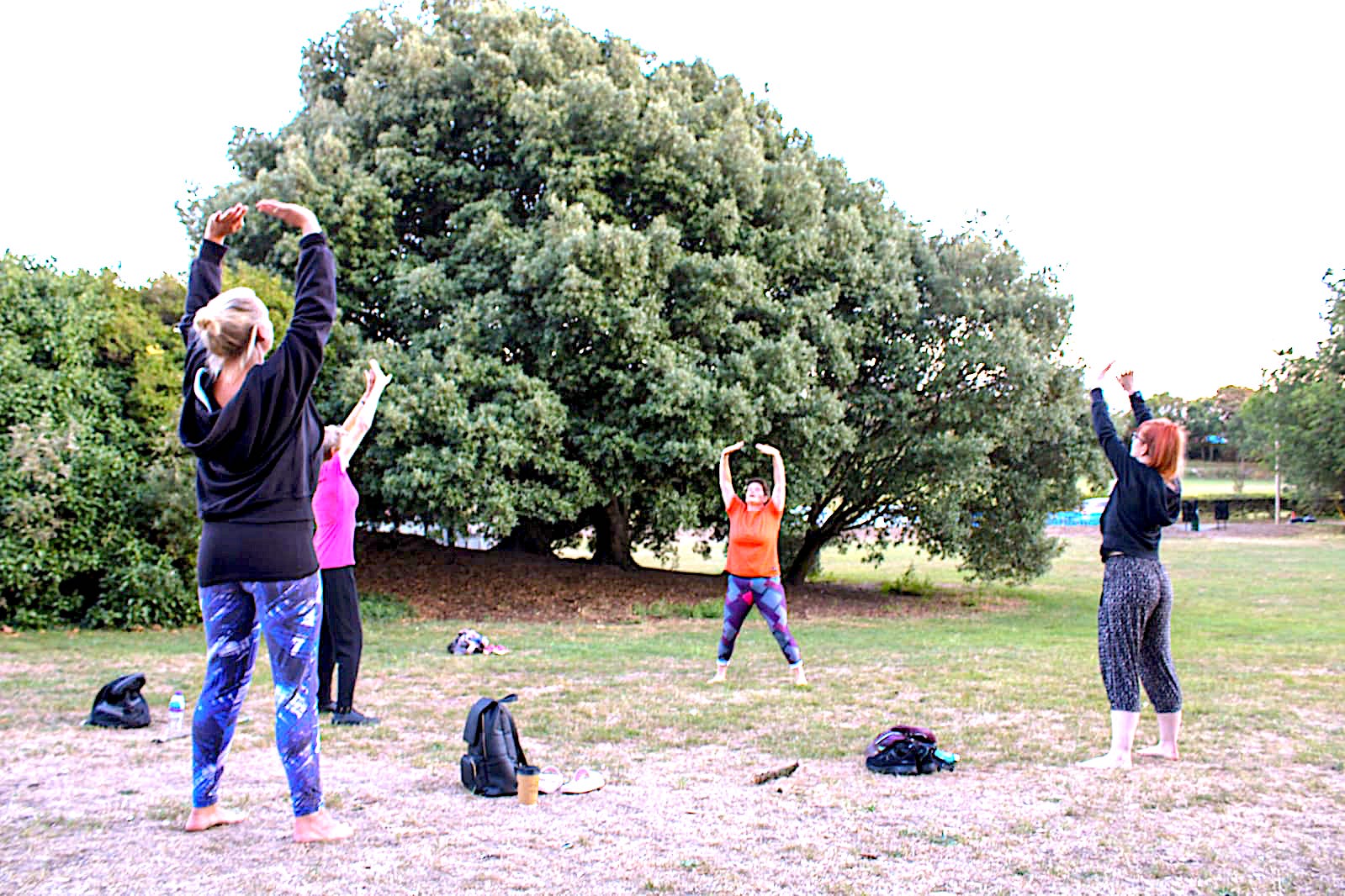 New students outdoors learning the basics of qigong, hands held softly in front of the body